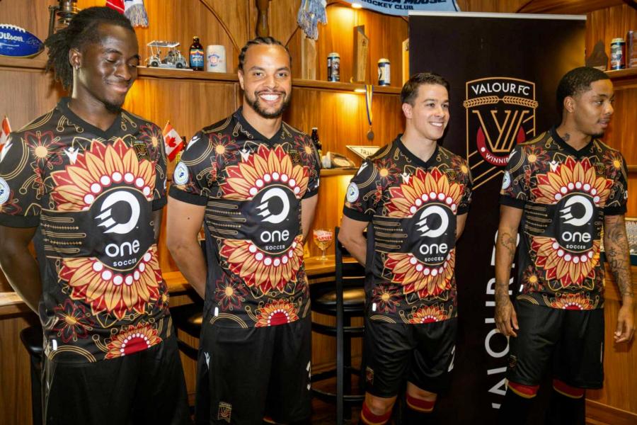 Four members of Valour FC wearing the new secondary Valour FC kits which feature an Indigenous-inspired design.