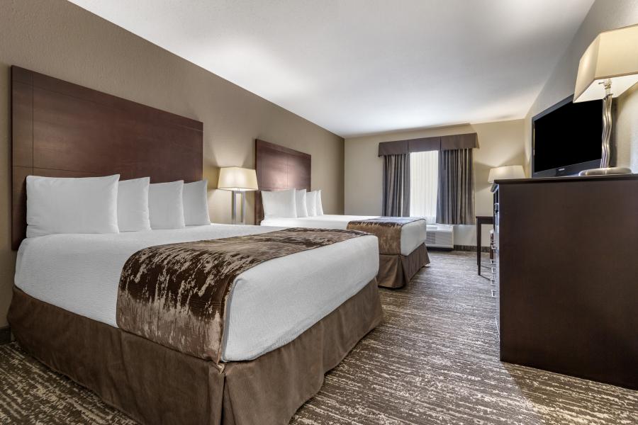 View of hotel room with two beds and a dresser