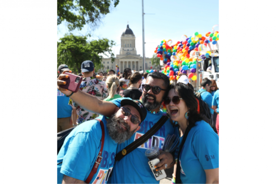 3 people taking a photo at pride parade