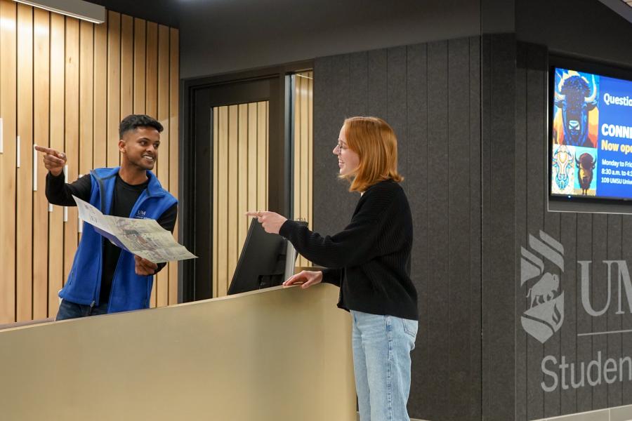 Connection desk student staff giving directions to a student pointing where to go