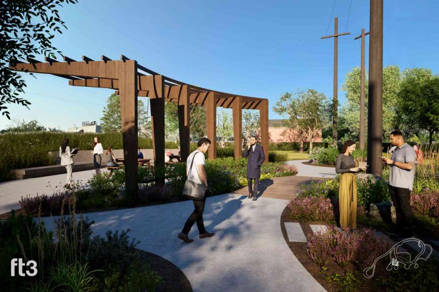 People standing at the intersection of paths in the Garden for Well-being. Shrubs, flowers and grasses border the paths.