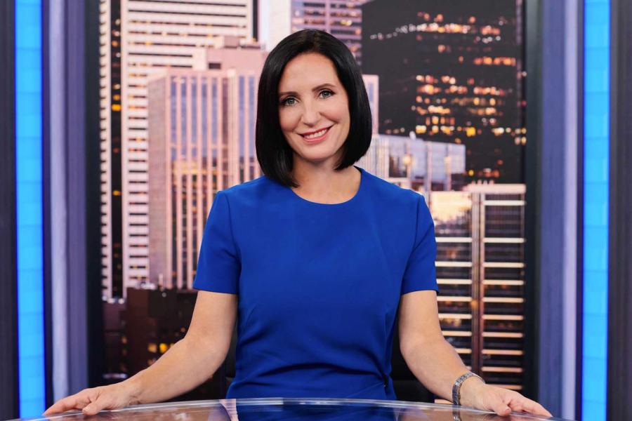 A photo of Amanda Lang sitting at a news desk.