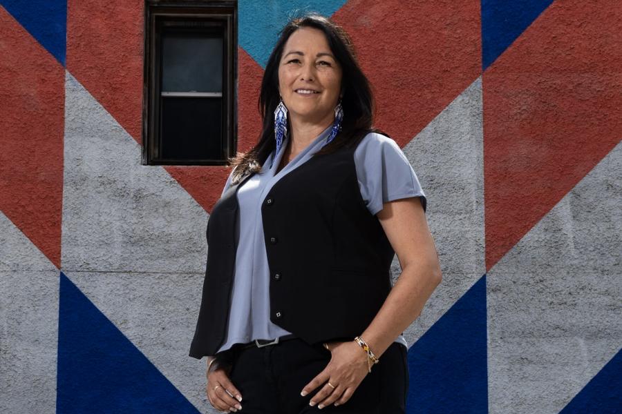 UM alum Diane Roussin poses in front of a star blanket mural.