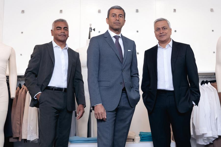 Ash Modha, Raj Bahl and Prashant Modha pose in front of clothing items. Photo by Thomas Fricke