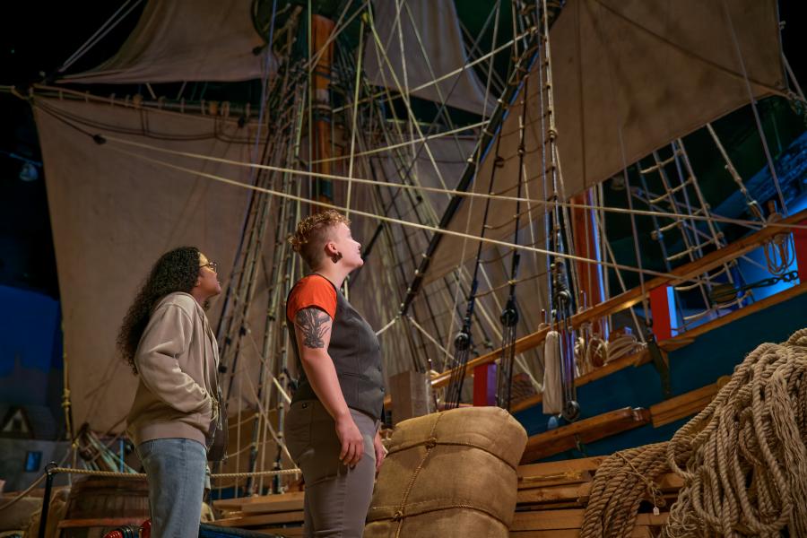 Young man and lady looking up at the Nonsuch ship in the museum