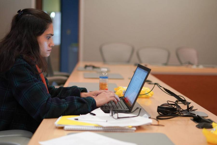 Student working at laptop in graduate writing workshop