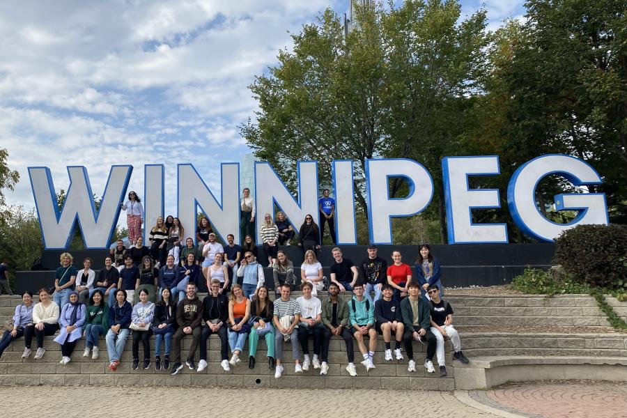 Photo of exchange students in front of the Winnipeg sign at the Forks.