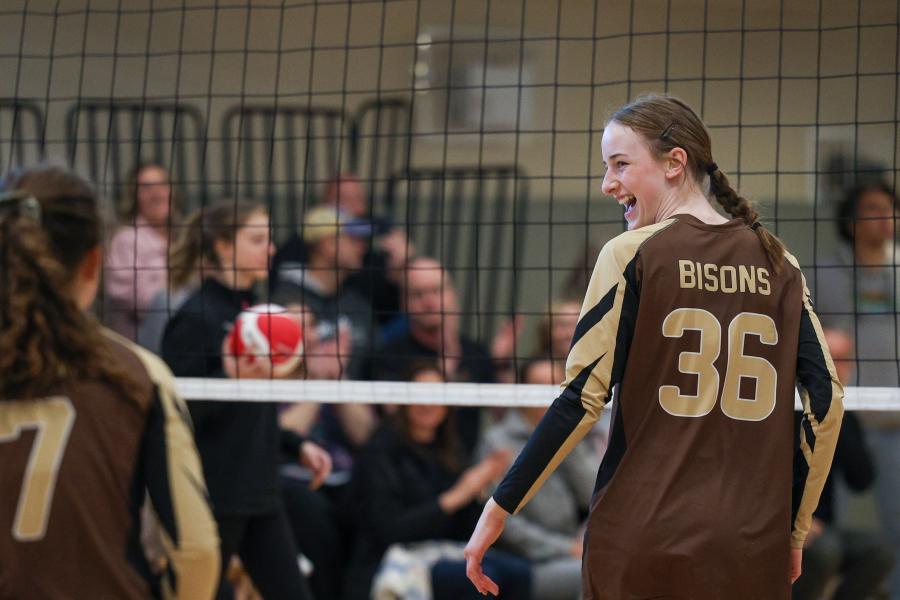 Junior Bison athlete smiling at teammate