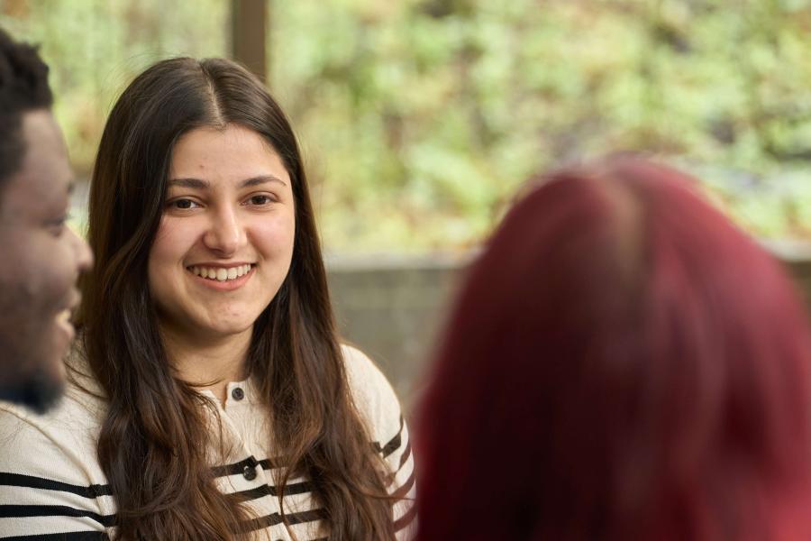 A student smiles in a group on campus.