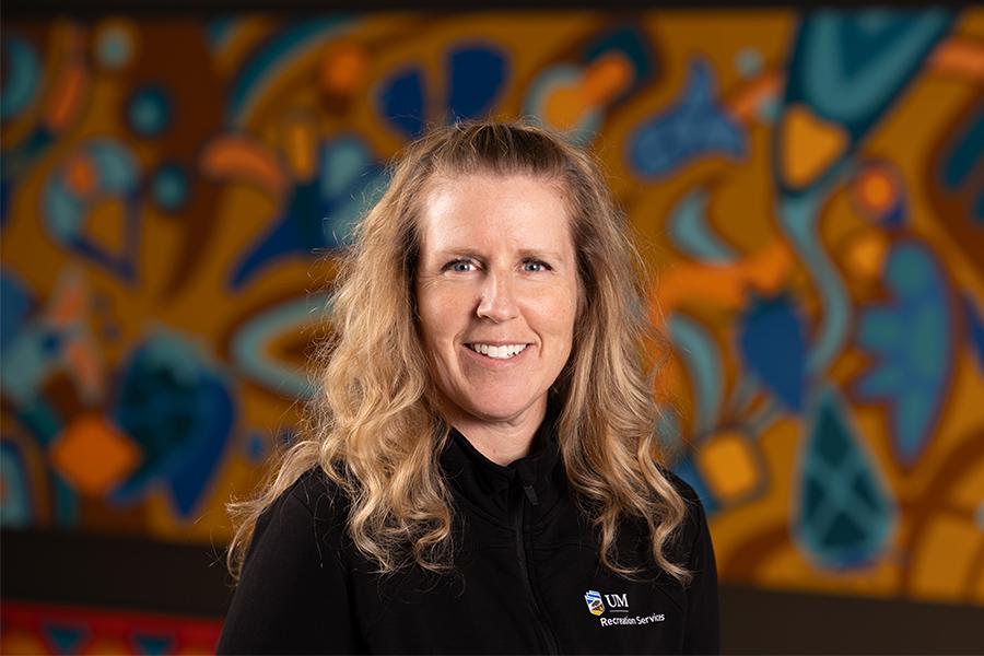 Faralee Wilson smiles in front of a colourful background.