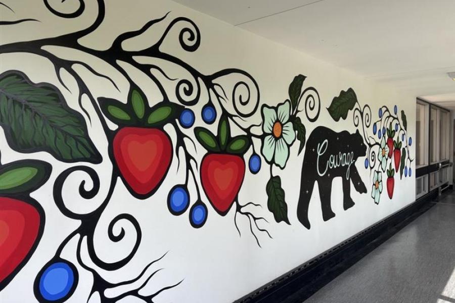 An indigenous mural depicting flowers, fruits and a bear along with the word "courage".