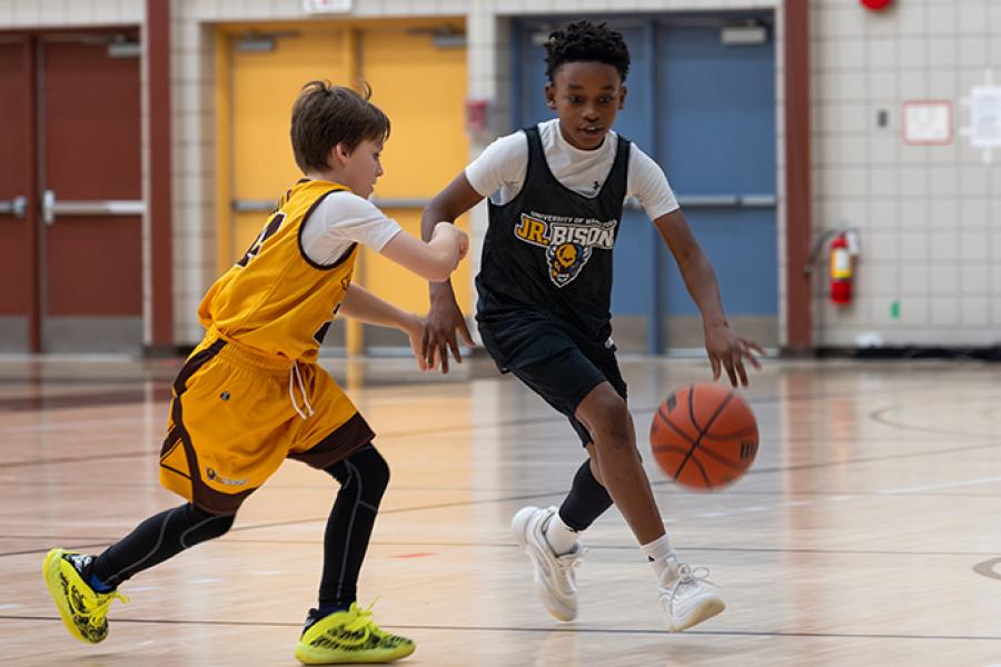 Two boy play basketball at at Junior Bisons practice.