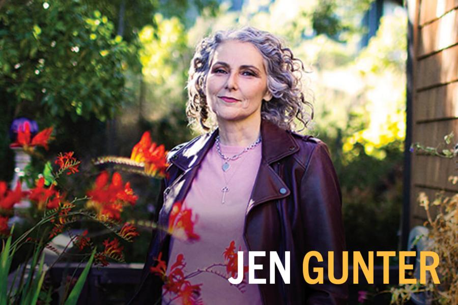 Headshot of Jen Gunter outside with flowers in foreground and trees in background.