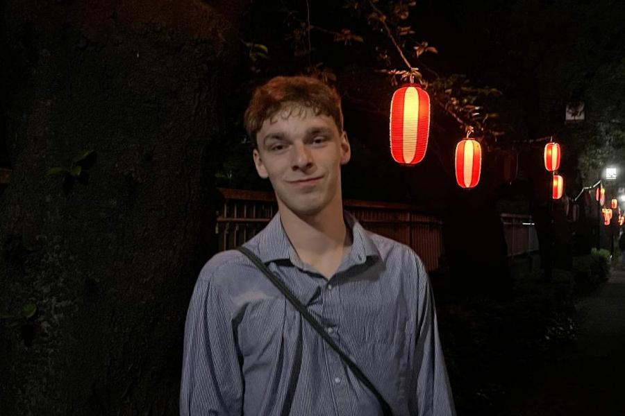 Karl poses on a street in Japan at night, with red lanterns illuminating the scene.