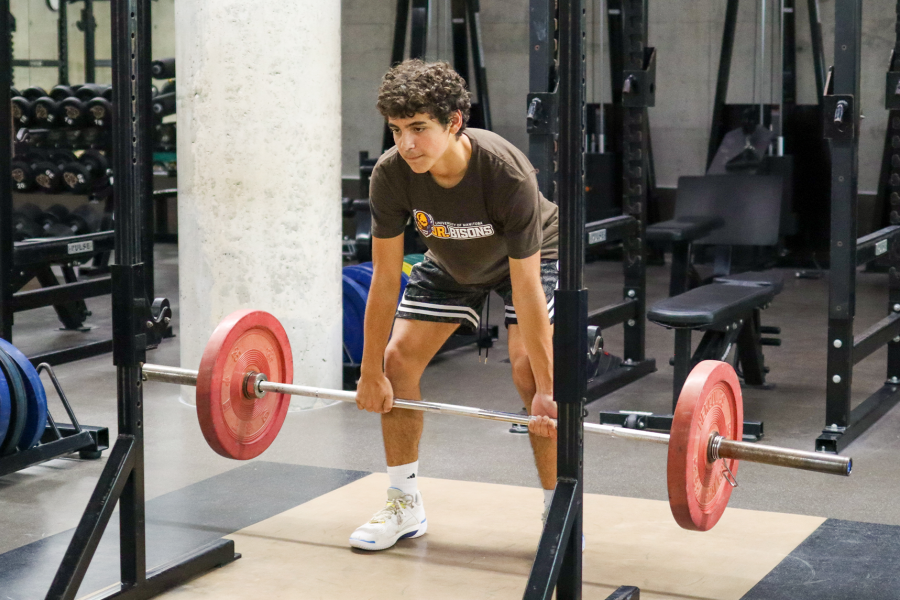 A Junior Bisons athlete performs a deadlift in the high performance training centre.
