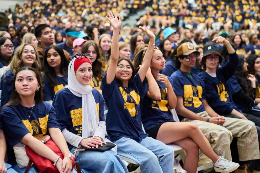 Students in UM shirts cheer during Welcome Day. 