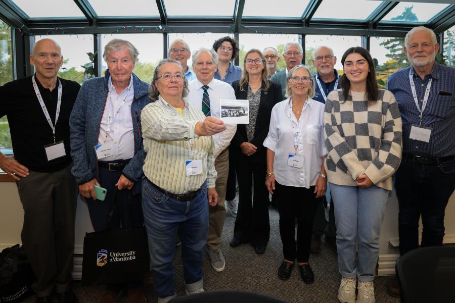 Natural Resources Institute 75-77 Reunion Group photo holding their original group photo from mid 70's