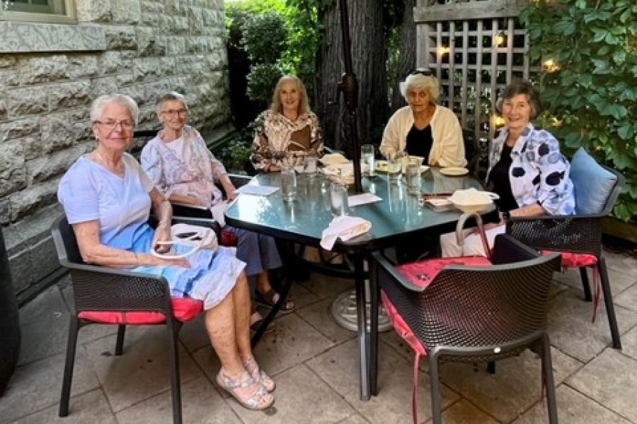 5 members of the Home Economics Class of 1961 seated at a patio table