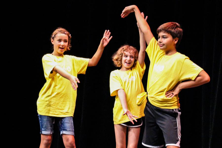 Three Mini U participants on stage during a group performance.