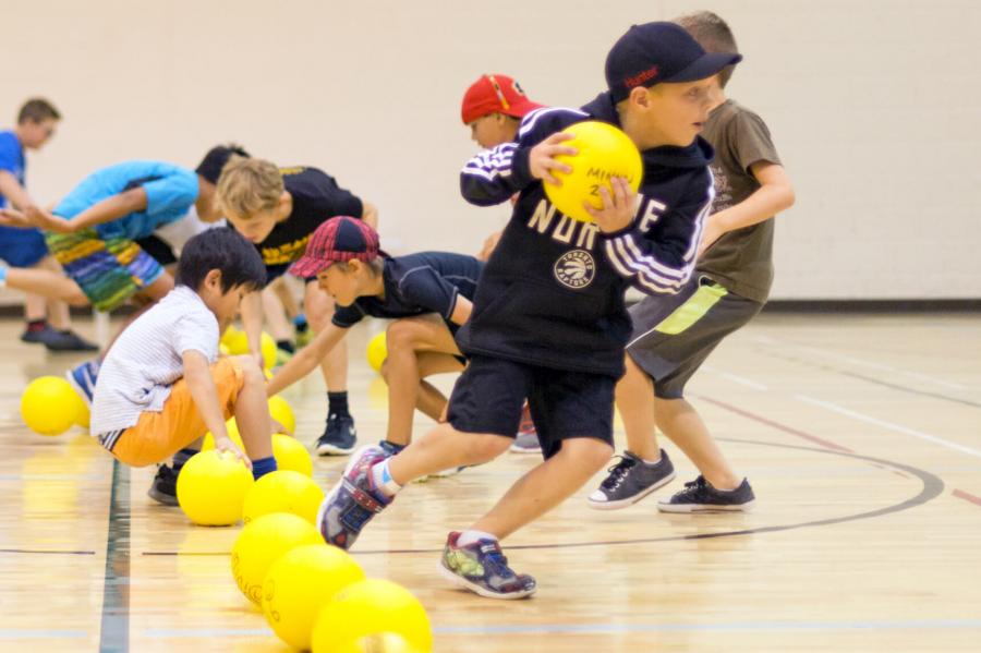 Players rush to grab the dodgeballs during a dodgeball game.