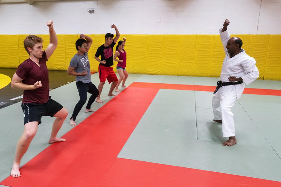 Instructor teaching karate stance to four students