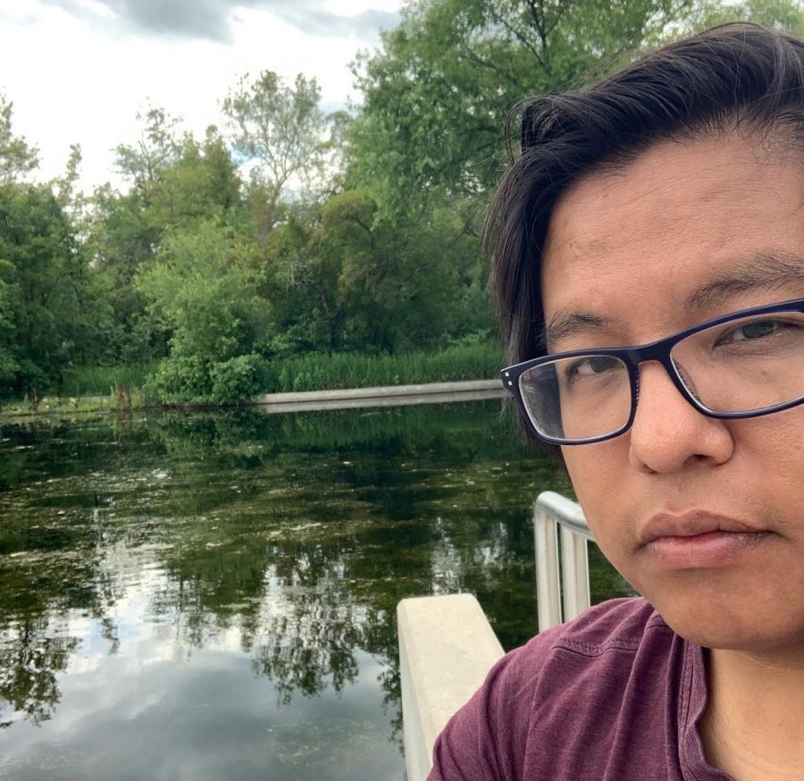 man standing in front of a pond