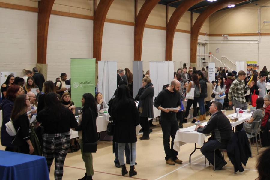 A large room filled with students visiting various booths during Field Info Day. 