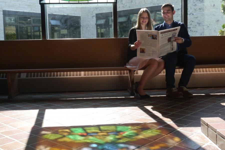 Two students read the student newspaper 