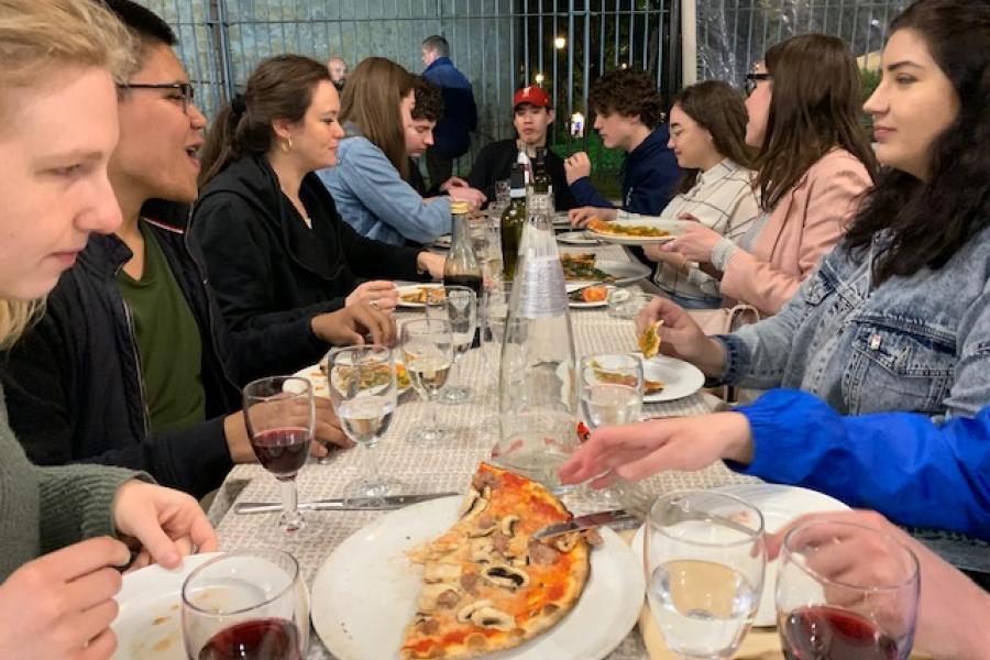 students eating pizza at a table