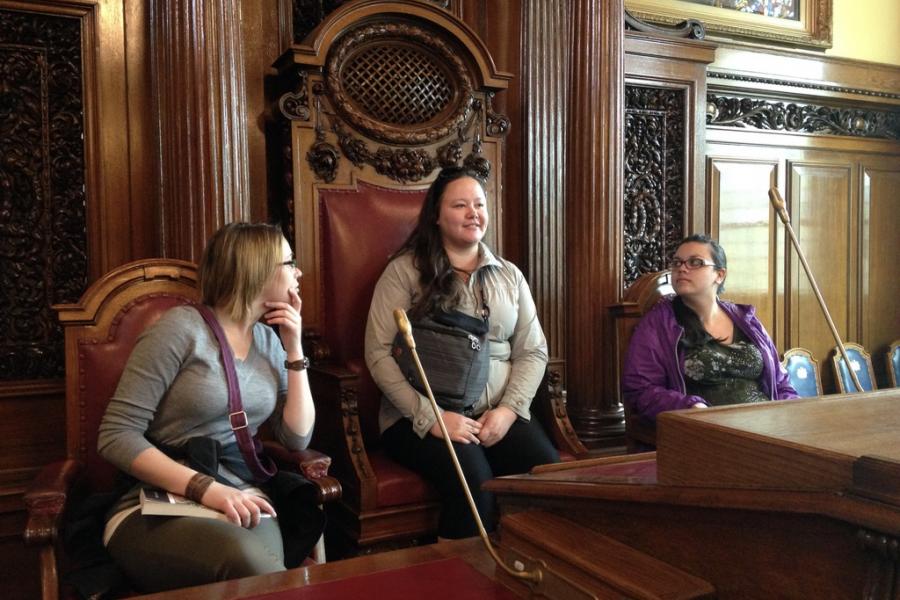 students sitting in large chairs in belfast city council chambers