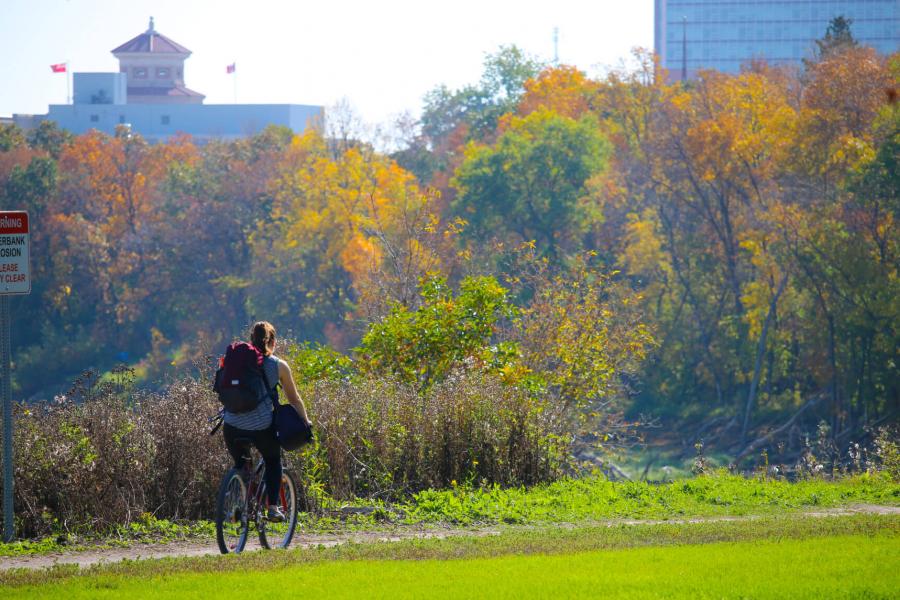 A cyclist approaches the University of Manitoba Fort Garry campus on a scenic fall day.