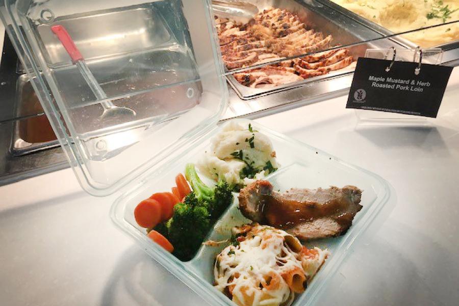 Pembina Hall cafeteria food in a reusable take out container