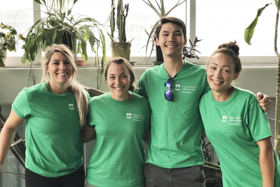 Four sustainability ambassadors stand in front of a variety of plants.